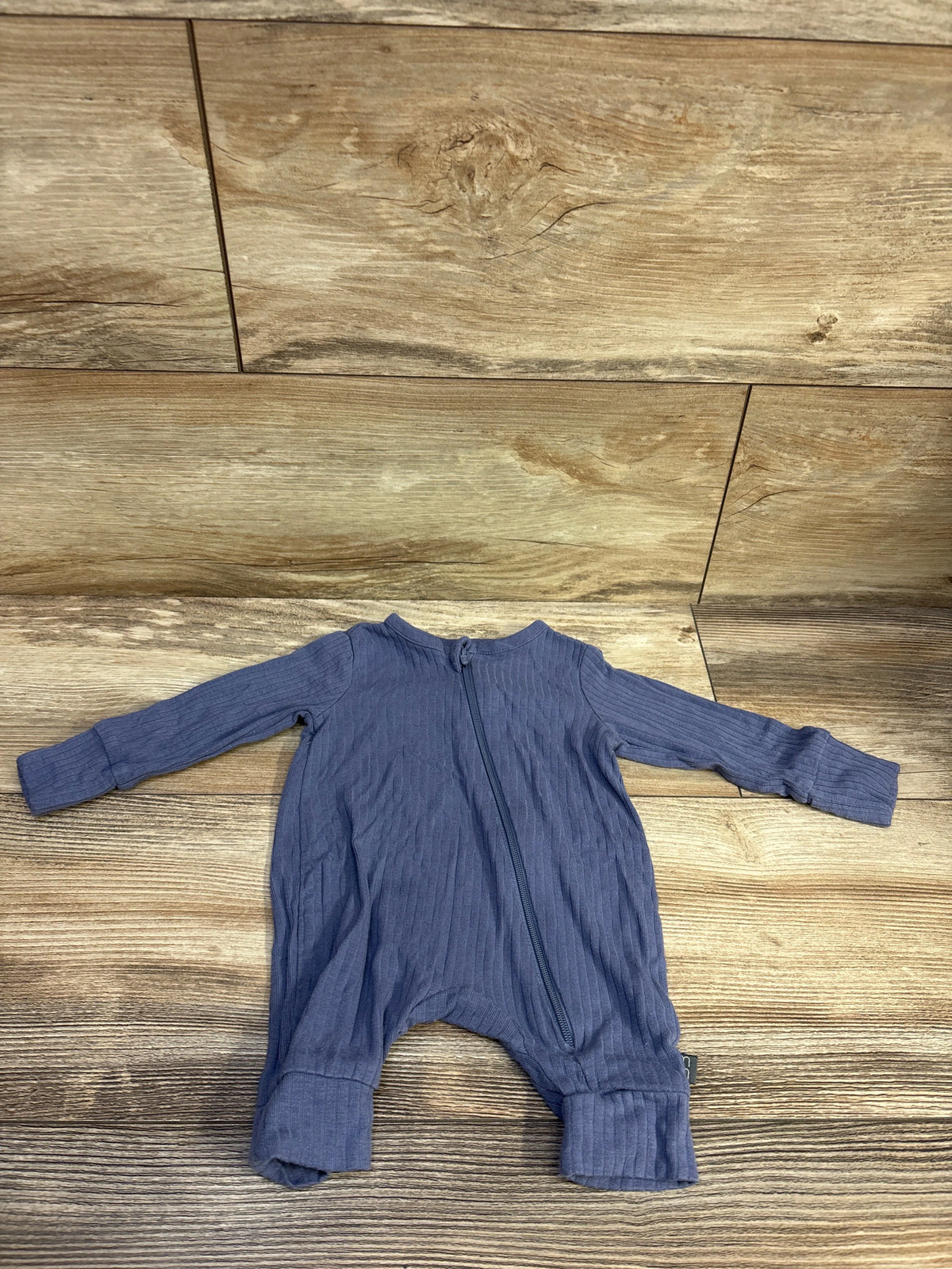 Front view of blue ribbed footless viscose sleeper showcasing full length zipper and long sleeves on a wood floor