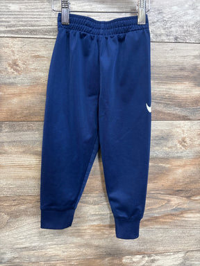 Navy blue toddler athletic pants with elastic waistband and white swoosh logo on wood background