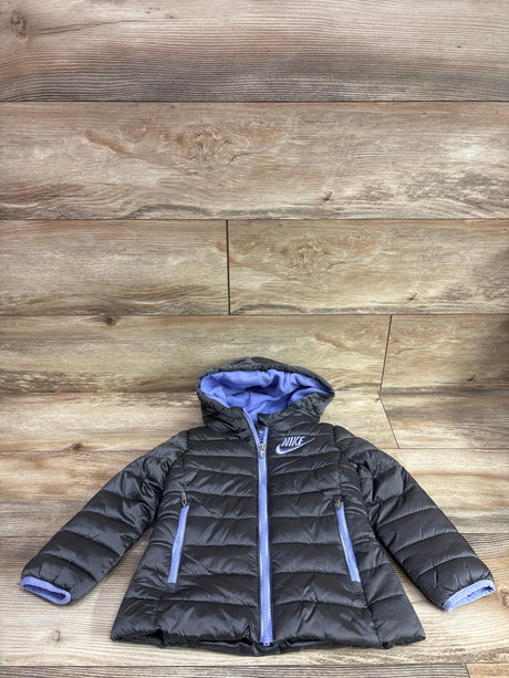 Front view of Nike hooded puffer jacket in grey showcasing purple-lined hood and zippered pockets on wood plank background