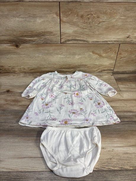 Flat-lay of Carter's white Henley dress with matching bloomers showing pink daisy print and elastic waist on wood background