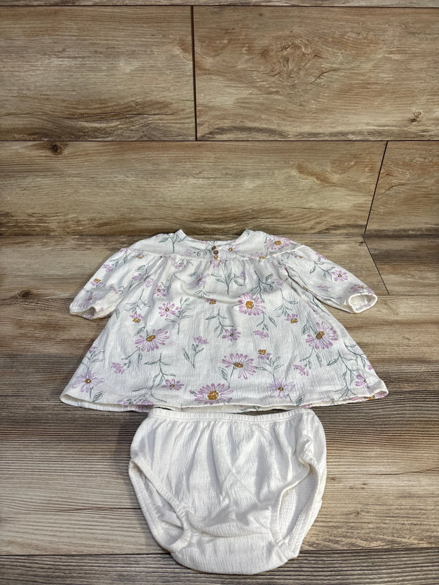 Flat-lay of Carter's white Henley dress with matching bloomers showing pink daisy print and elastic waist on wood background