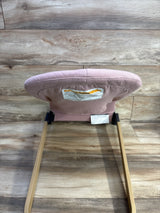 Rear view of ANGELBLISS portable baby bouncer in pink showcasing padded backrest and wooden rocker style legs on wood floor