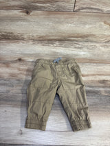 Flat lay of tan Carter's pull-on poplin pants size 6M showing elastic waistband with gray tie and elastic cuffs on wood