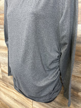 Gray long sleeve maternity top with side ruching, displayed on a wooden background