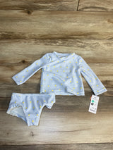 Baby long sleeve rash guard swimsuit set with yellow lemon print, size 6m, on wood background