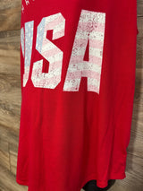 Close-up front of red Isabel Maternity tank top showing large distressed USA flag print with wood plank background