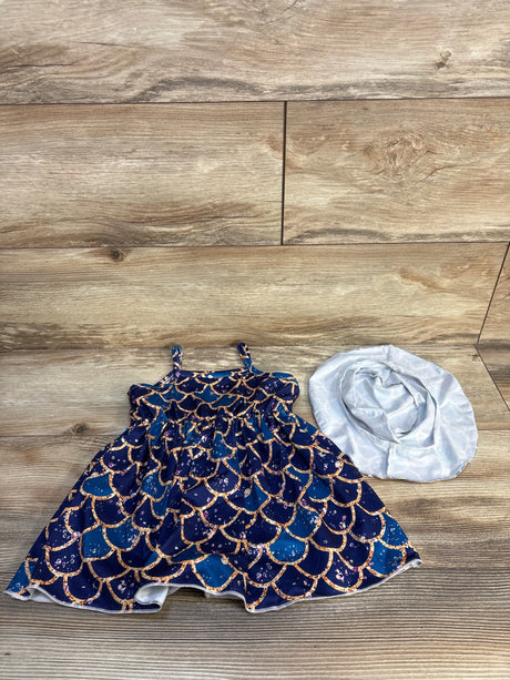 Girls' blue mermaid scale dress with matching white sunhat on wood background