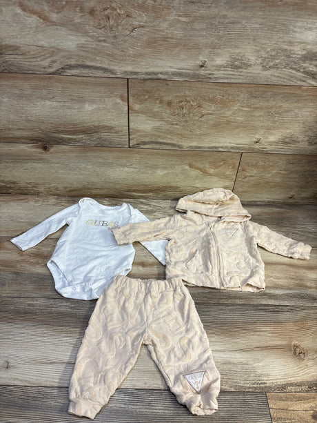 Front view of Guess Baby 3pc Zip-Up Jacket, Joggers, and Bodysuit Set in beige on a wood floor