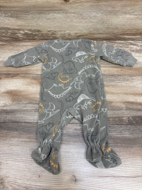 Front view of green Gerber blanket sleeper with dinosaur print, long sleeves, and covered feet on wood background