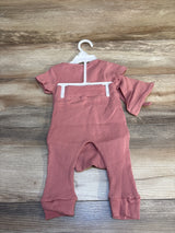 Ribbed pink baby romper with short sleeves on hanger, displayed on wood background