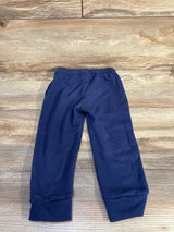 Flat lay of navy toddler jogger pants size 2T showcasing elastic waistband and ribbed cuffs on wood background