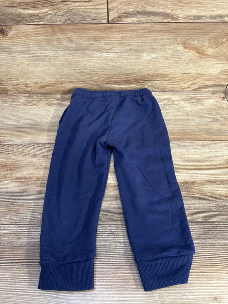 Flat lay of navy toddler jogger pants size 2T showcasing elastic waistband and ribbed cuffs on wood background