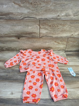 Flat lay of Cat & Jack 2T floral French terry set showing peach top with ruffle shoulders and matching pants on wood background