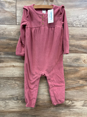 Carter's baby fleece pink jumpsuit with long sleeves, button details, and snap closures on rustic wooden background
