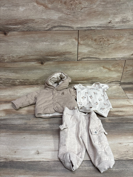 Top view of tan Rabbit and Bear three-piece set with hooded jacket, bear-print bodysuit, and pocketed pants on wood