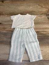 Baby outfit with short sleeve white shirt and light blue striped pants on wood floor
