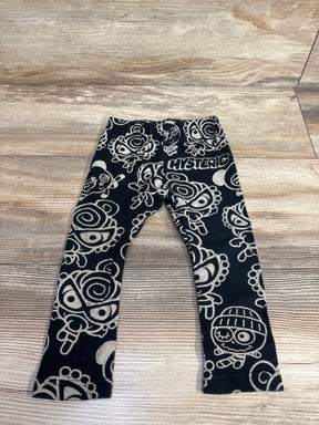 Black kids leggings with cartoon faces all-over print on wooden floor