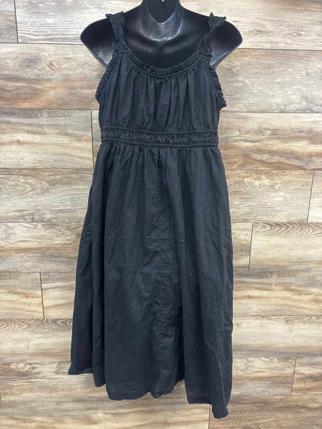 Front view of Old Navy black maternity sleeveless dress showcasing ruched straps and gathered waist on a wood-look floor