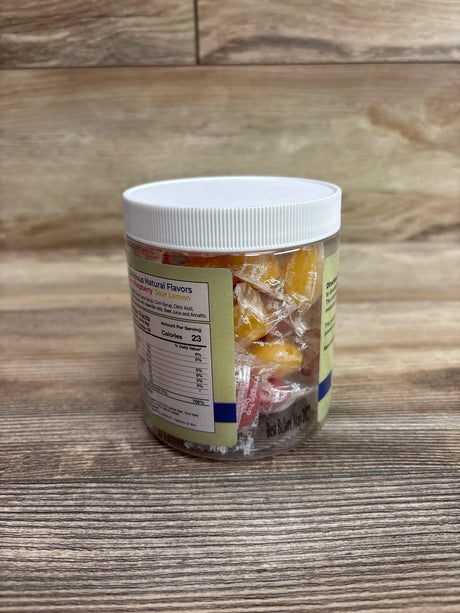 Three-quarter view of ThreeLollies Preggie Pop Plus Drops sour mix jar showing wrapped candies on a wood background