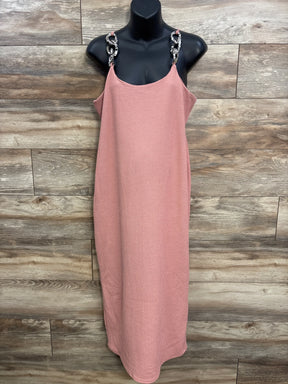 Pink textured sleeveless dress with chain straps on black mannequin against wood background