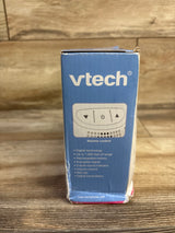 Front view of VTech DM111 baby monitor box showing VTech logo, volume control illustration and feature list on wooden table