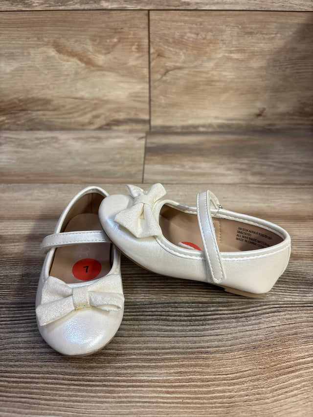 Front and side view of Sugar Nira toddler flats with glitter bows and Mary Jane strap, size 7C sticker, wood background
