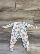 Front view of Old Navy newborn footed sleeper in beige with rainbow, cloud and flower print and ruffle shoulders on wood floor