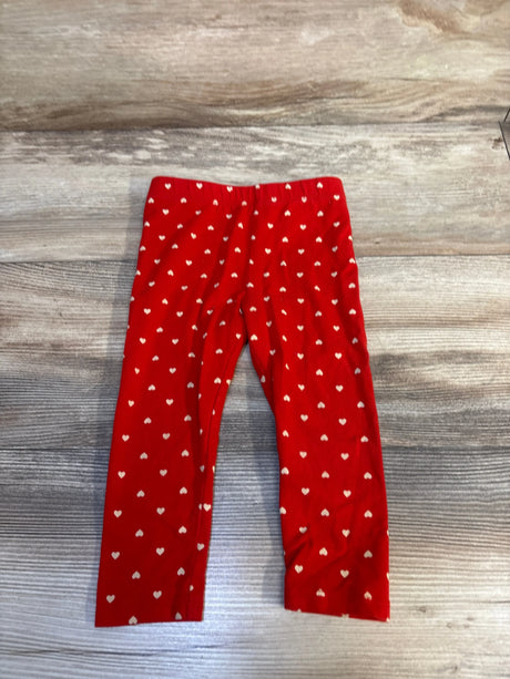 Flat lay of Cat & Jack Hearts Leggings sz 18m in red with white heart print and elastic waist on wood plank floor