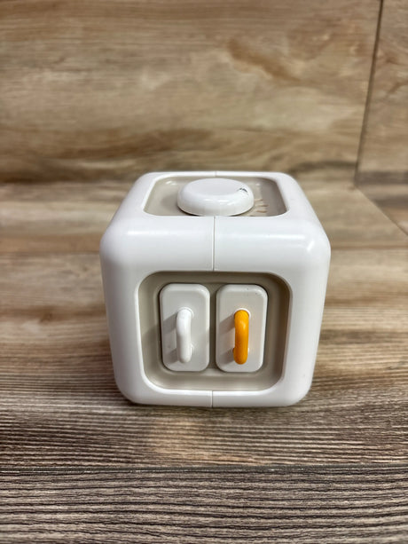 Front view of SOCBTNSO Montessori Busy Cube showcasing two front toggle switches and a top dial with a wood-grain background