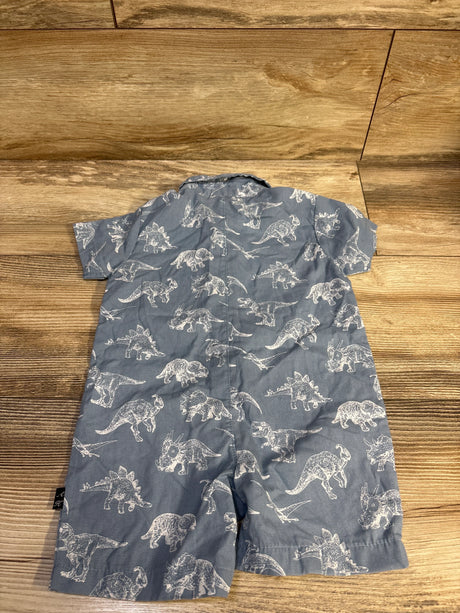 Back view of blue baby polo romper with all-over white dinosaur print, size 12 months, flat on light wood background