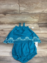 Top view of teal Old Navy baby two-piece smocked embroidered tank top and bloomer shorts showcasing scalloped embroidered hem on wood background