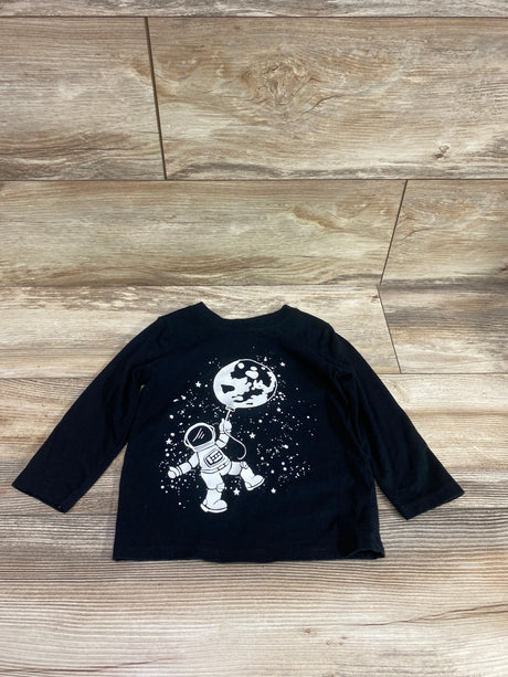 Front view of Cat and Jack black long sleeve shirt in size 2T showcasing an astronaut and moon graphic on a wood floor