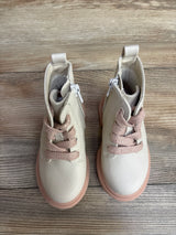 Pair of toddler cream-colored boots with pink laces and rubber soles on wood floor