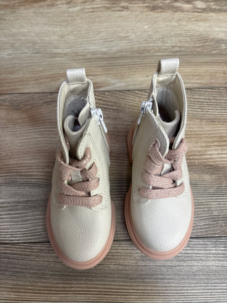 Pair of toddler cream-colored boots with pink laces and rubber soles on wood floor
