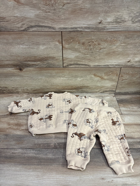 Top view of H&M and Disney Winnie the Pooh two-piece sweatshirt set showcasing beige quilted fabric and character print on wood background