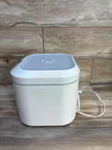 White electric baby wipe warmer with lid and power cord on wood background