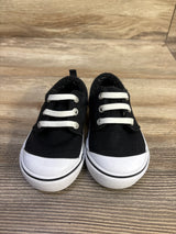Front view of Wonder Nation canvas bump-toe toddler sneakers in black showing white rubber toe caps and elastic laces on wood background