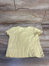 Back view of a short sleeve yellow kids t-shirt on wood background