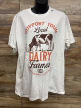Front of white maternity T-shirt with 'Support Your Local Dairy Farmer' cow graphic and orange DAIRY text on wood backdrop