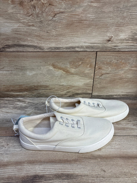 Side view of Cat and Jack Tyler off-white slip-on sneakers size 5Y with canvas upper and white rubber sole on wood floor