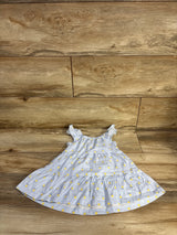 Top-down view of Just One You girls' blue tiered dress with ruffle straps and yellow floral print on wood floor