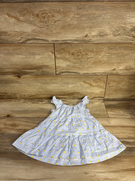Top-down view of Just One You girls' blue tiered dress with ruffle straps and yellow floral print on wood floor