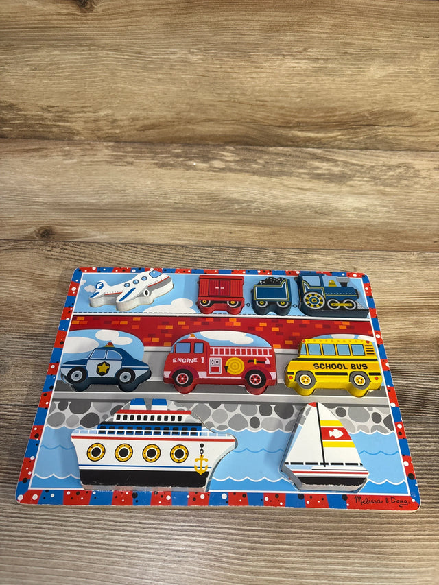 Top-down view of Melissa & Doug wooden chunky puzzle showcasing nine colorful vehicle-shaped wooden pieces on a wood table