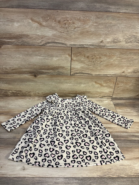 Front view of Jumping Beans ivory dress with long sleeves, ribbed texture, and leopard print on a wood background