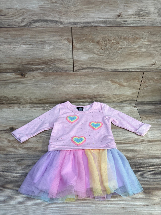 Front view of pink Zunie sweatshirt tulle dress showcasing long sleeves, heart embellishments, and rainbow tulle skirt on wood floor
