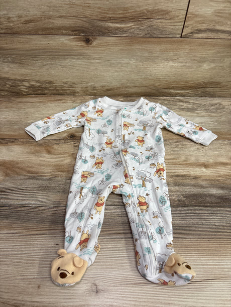 Top view of white Disney Baby Winnie the Pooh sleeper with character print, front zipper, and bear feet on wood