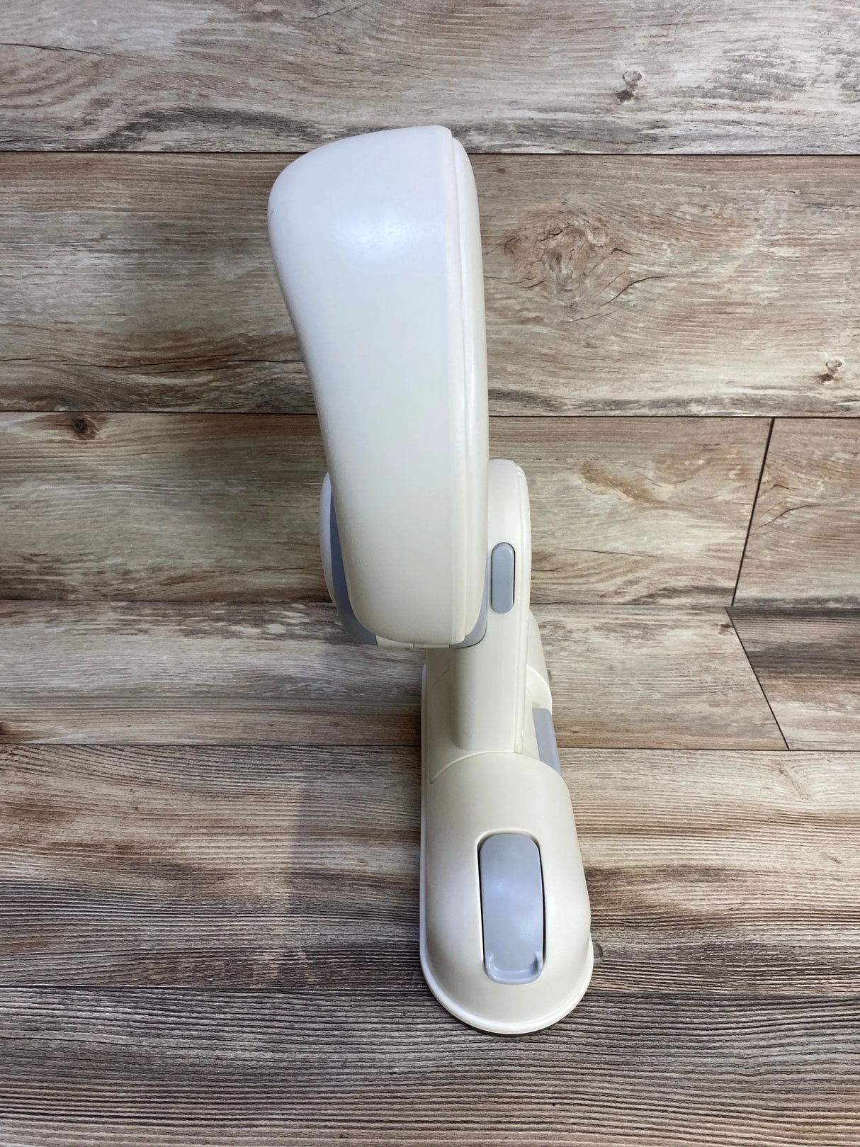 Side view of IvyWind wall-mounted baby shower stand showing adjustable cream plastic bracket with suction-cup mounts on wood backdrop