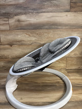 Side view of Munchkin Bluetooth enabled baby swing with gray plush seat insert, three-point harness, and white circular base