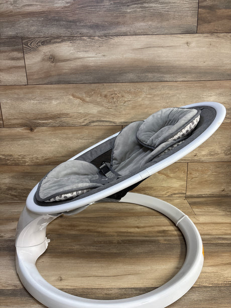 Side view of Munchkin Bluetooth enabled baby swing with gray plush seat insert, three-point harness, and white circular base