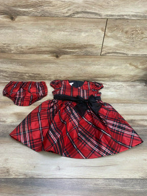 Flat lay of Bonnie Jean plaid toddler dress and bloomers showing puff sleeves, black waist bow on wood background